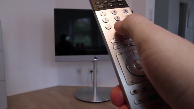 Man mit Fernbedienung Abends vor dem Fernseher