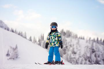 Cute preschool child, boy, skiing happily in Austrian ski resort