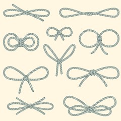 Set of decorative rope bows on beige background