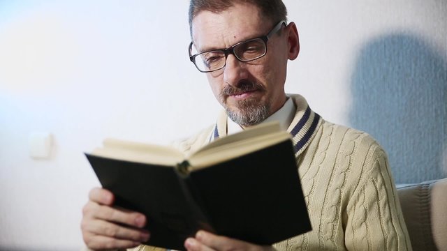 a grown man reading a book