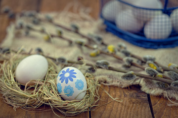 Decorated Easter eggs in nest on rustic wooden background