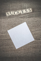 Success concept. Wooden blocks forming Success word on top of a blank paper