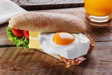 Sandwich with tomato bacon cheese and egg