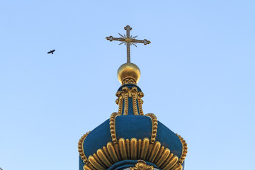 Fototapeta na wymiar The dome of the church and flying crows/The dome of the church and crows flying in the blue sky
