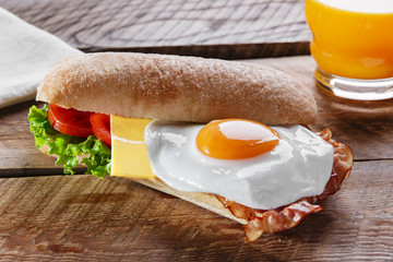 Sandwich with tomato bacon cheese and egg