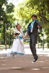 romantic couple jumping and smiling  on background park