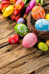 Obraz na płótnie Canvas Easter eggs and tulips on wooden planks