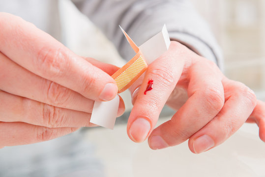 Applying adhesive bandage on finger