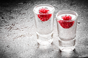 Raspberry vodka glass shot with fruit inside.