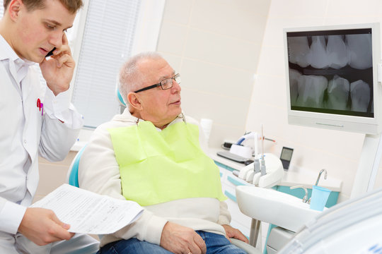 Elderly man on a review of a dentist, sitting in a chair