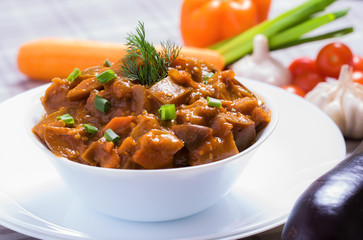 Baked eggplant with vegetables in white dish
