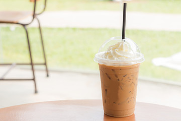 Ice coffee in a cafe with garden background.