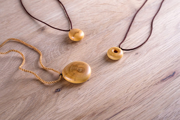 Necklaces made of wood on wooden background.