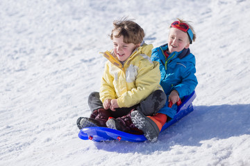 Two cheerful boys on sledge