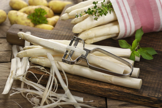 Erntefrischer Stangenspargel mit Kartoffeln auf Holzbrett