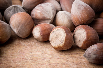 Hazelnuts on wooden table background.