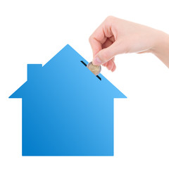 woman hand putting euro coin inside house money box