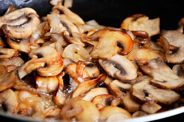 sliced mushrooms stir-fried in a pan. close-up full frame