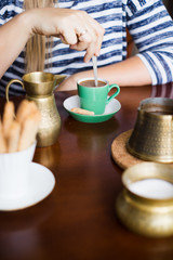 Woman stirring coffee with teaspoon. Selective focus