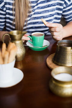 Woman drinking coffee with cookies. Selective focus