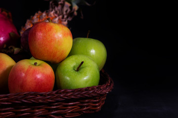 Still life apples with bamboo basket on black backgound