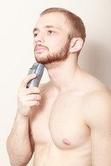 Fototapeta premium bearded guy shave electric razor