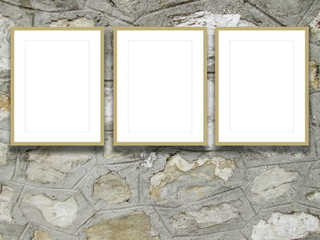 Close-up of three beige picture frames on old stone wall background