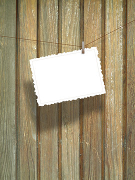 Close-up of one hanged postcard on vertical wooden boards background