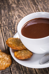 White cup of hot chocolate with homemade oat cookies.