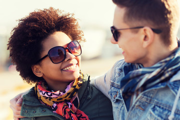 happy teenage friends in shades talking outdoors