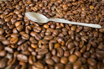 Small silver spoon and coffee beans