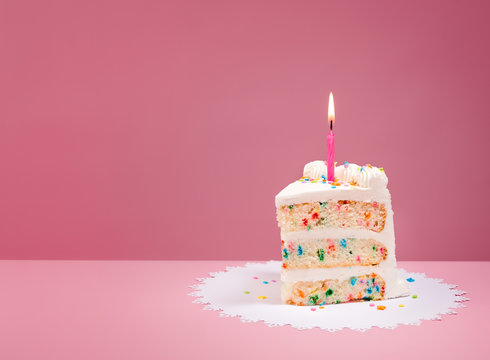 Naklejki Slice of Birthday Cake with Candle on Pink