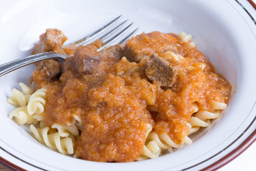 Served beef stew with macaroni in the metal plate
