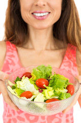 Friendly woman showing a bowl of salad