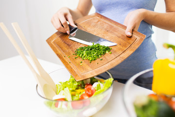 close up of woman with chopped onion cooking salad