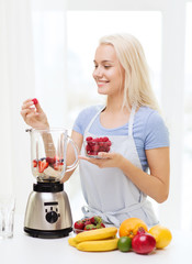 smiling woman with blender preparing shake at home