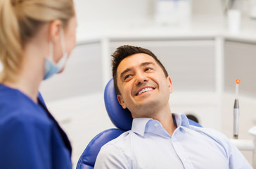 female dentist with happy male patient at clinic
