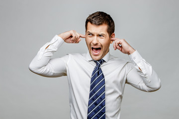 Handsome stylish businessman on grey background