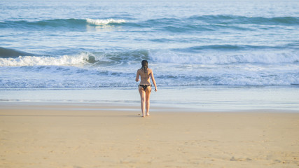 Mujer caminando por la orilla de la playa