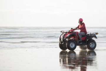 Fototapeta premium Happy ATV driver on the Ninety Mile Beach, New Zealand