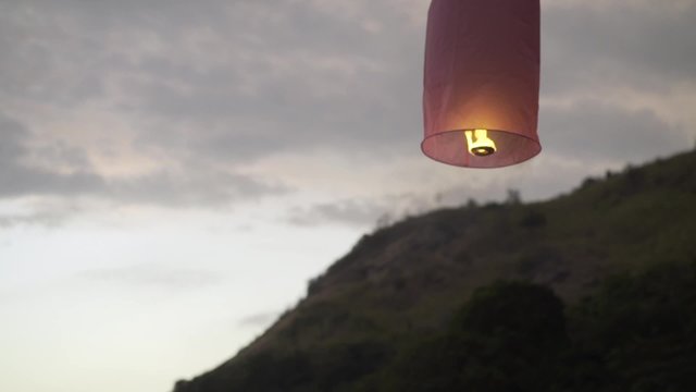 Happy couple in love launches  Chinese lantern  on the beach.  Strong family.