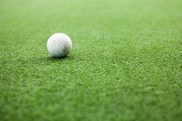 Golf ball on green field during sunset