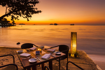 Naklejka premium Romantic sunset on the shore of a tropical island. Cafe on the b