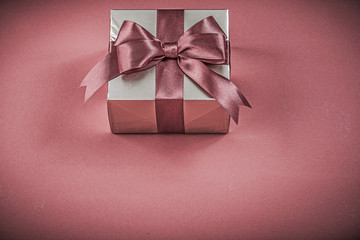 Packed gift container on red background holidays concept