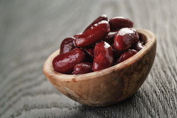 red beans from can in wood bowl, on wooden table