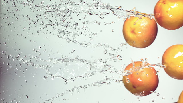 grapefruits are flying with a jet of water,  white  background, slow motion