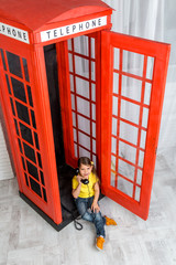 little girl sitting in phone booth