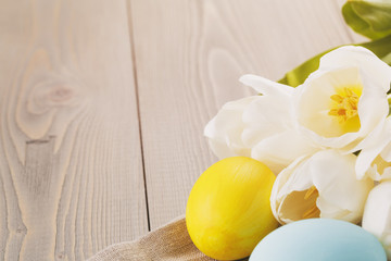 hand painted easter eggs on table with tulips, vintage toned