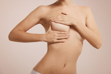 Breast cancer self check, healthy lifestyle concept. Young pretty woman examining her breast for...