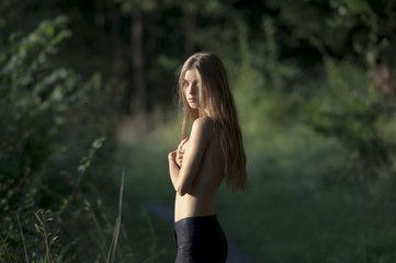 girl in black leggings standing in the woods